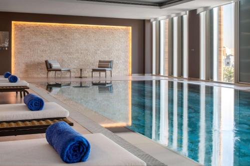 a pool in a hotel room with blue pillows on beds at Hilton Garden Inn Riyadh Financial District in Riyadh