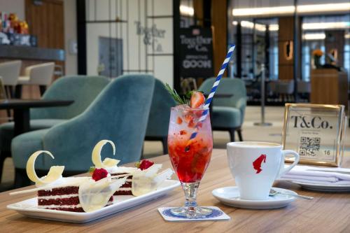 a table with a plate of cake and a drink at Hilton Garden Inn Riyadh Financial District in Riyadh