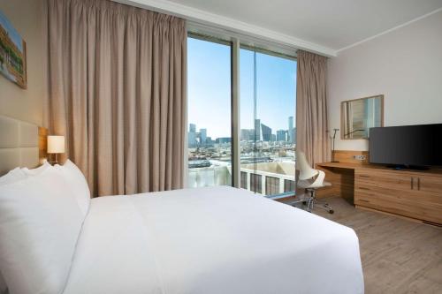 a hotel room with a white bed and a large window at Hilton Garden Inn Riyadh Financial District in Riyadh