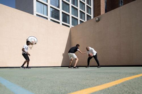 a group of three men playing a game of basketball at Hilton Garden Inn Riyadh Financial District in Riyadh