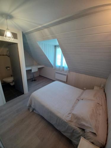 une chambre avec un grand lit dans un grenier dans l'établissement La Suite du Vieux Moulin, à Luchon