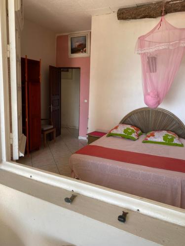 a bedroom with a bed with a pink curtain above it at La Porte Du Paradis in Fort-de-France