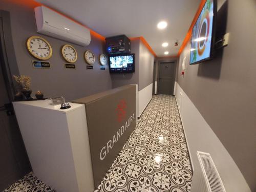 einen Flur mit Uhren an der Wand und einem TV in der Unterkunft GRANDAURA EDıRNE in Edirne