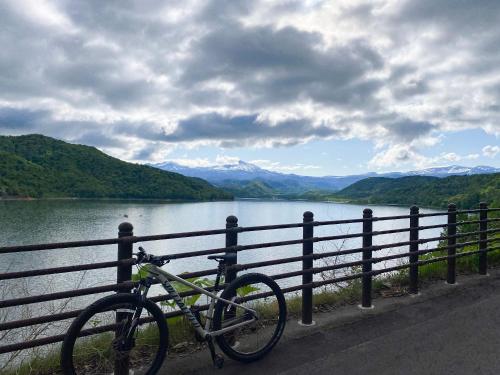 a bike parked next to a fence next to a lake at RONENAI BASE in Biei