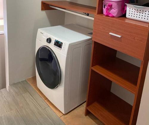 a washing machine in a kitchen next to a shelf at Cabaña de Montaña Flaki's in Monteverde Costa Rica