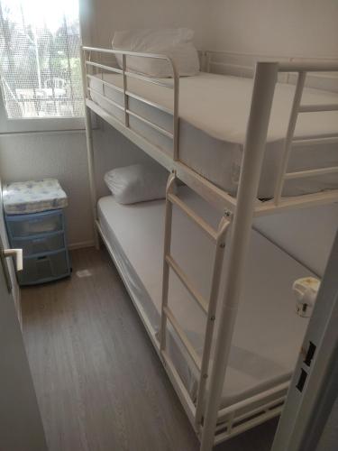 Dormitorio con 2 letti a castello e finestra. di Résidence les caraïbes Cap d'agde - Centre Port- Parking Gratuit-Terrasse - wifi 5G a Cap d'Agde