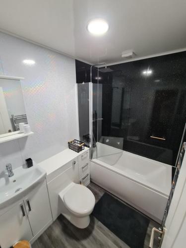 een badkamer met toilet, bad en wastafel bij City Centre Apartment in Aberdeen