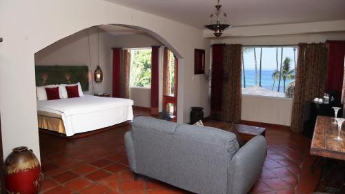 a bedroom with a bed and a living room with a couch at La Concha Beach Hotel & Club in La Paz