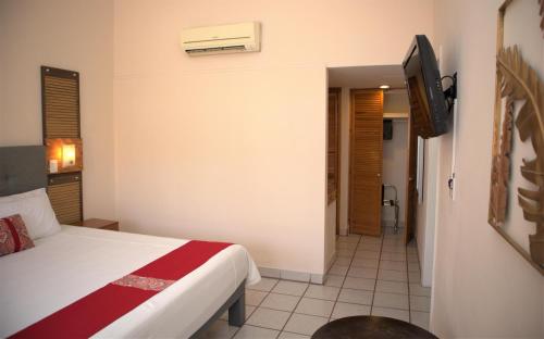 a hotel room with a bed and a television at La Concha Beach Hotel & Club in La Paz