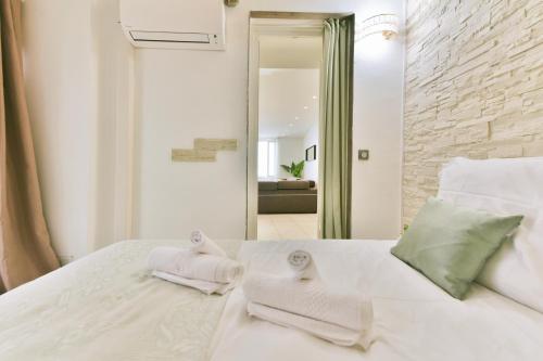 une chambre avec un lit blanc avec des serviettes dessus dans l'établissement Grand appartement- Le Port A/C, à Nice