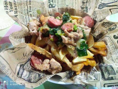 um prato de comida com batatas fritas e carne em HOSTAL FAMILIAR em Chillán