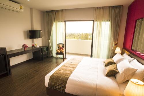 a bedroom with a large bed and a large window at Coco View Hotel in Samut Songkhram