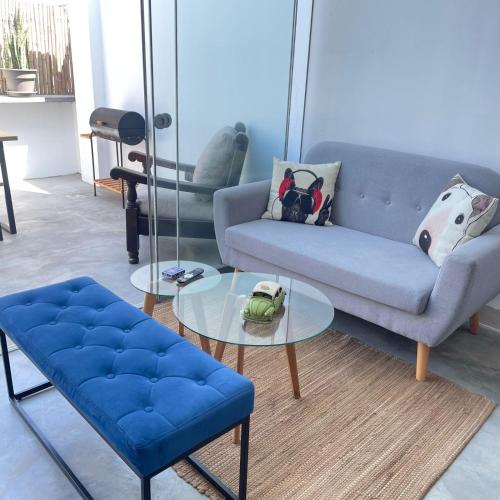 a living room with a blue couch and a glass table at Departamento de Playa en Punta Hermosa in Punta Hermosa
