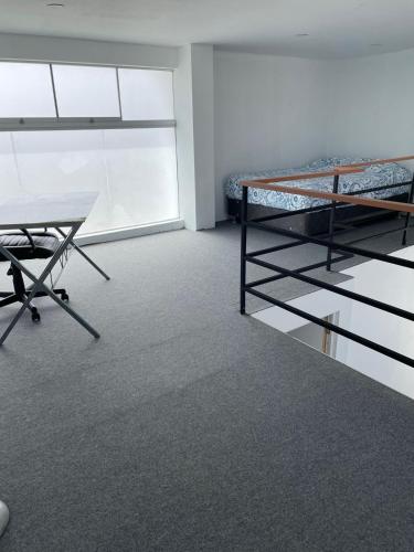 Cette chambre comprend un lit, un bureau et une table. dans l'établissement Departamento de Playa en Punta Hermosa, à Punta Hermosa