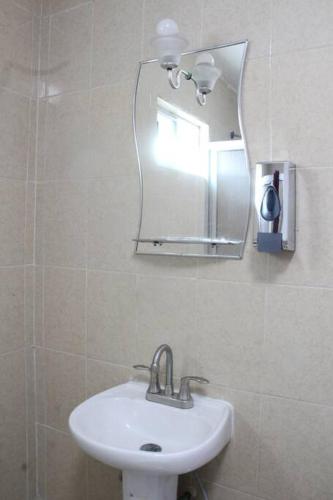 a bathroom with a sink and a mirror at Conexión Perfecta Entre Playa y Aviones in Tampico