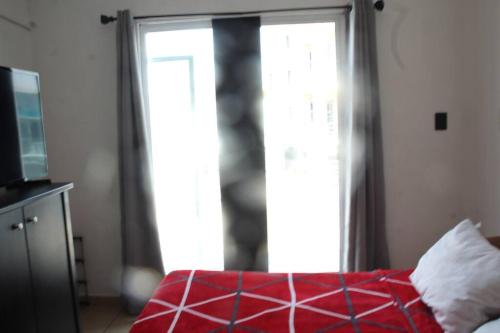 um quarto com uma cama vermelha e uma janela em Amplia Casa/Residencia a 15 Minutos de playa Miramar y Altama em Tampico