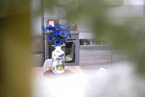 un vaso con fiori blu su un tavolo in cucina di Home Civico 19 a Sannicandro di Bari