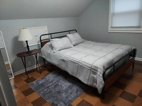 1 dormitorio con cama, lámpara y mesa en The Lodge@ Kendon, en Lansing