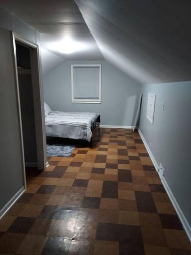 a bedroom with a bed and a checkered floor at The Lodge@ Kendon in Lansing