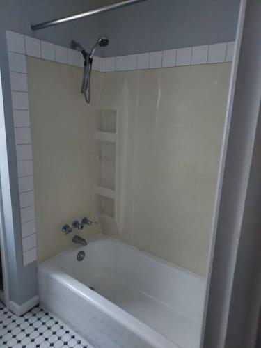 a white tub in a bathroom with a tiled floor at The Lodge@ Kendon in Lansing