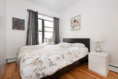 a white bedroom with a bed and a window at 1BR in Upper West Side in New York