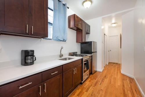 a kitchen with wooden cabinets and a sink at 1BR in Upper West Side in New York