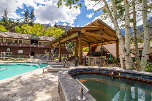 a swimming pool with a grill and a building at Twin Peaks Lodge & Hot Springs in Ouray