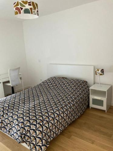 een slaapkamer met een bed, een tafel en een lamp bij Very nice 40 m quiet in Suresnes with parking in Suresnes