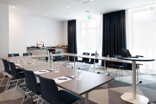 a conference room with tables and chairs and windows at Holiday Inn Express - Remscheid in Remscheid