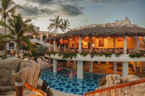 Mar del Cabo By Velas Resorts في سان خوسيه ديل كابو: منتجع فيه مسبح ومبنى