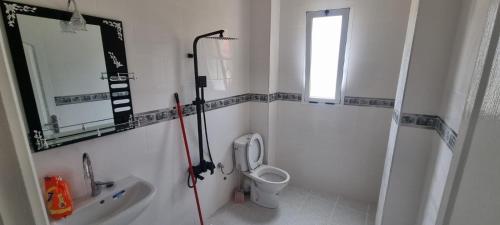 La salle de bains est pourvue de toilettes, d'un lavabo et d'une fenêtre. dans l'établissement Familie appartement Alhoceima, à Ajdir