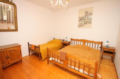 1 Schlafzimmer mit 2 Betten und einem Spiegel in der Unterkunft Apartments by the sea Unesic - Unije, Losinj - 8044 in Unije