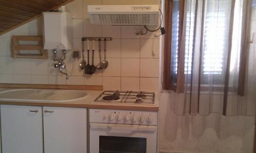 a small kitchen with a stove and a sink at Apartments by the sea Unesic - Unije, Losinj - 8044 in Unije
