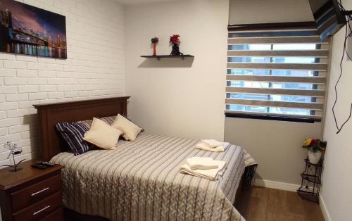a bedroom with a bed with two towels on it at Monoambiente totalmente equipado y centrico in Cochabamba