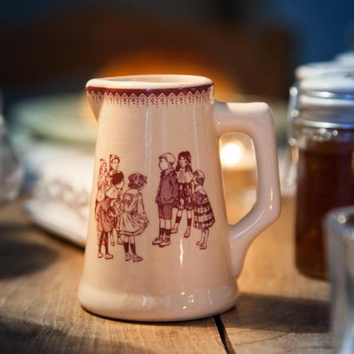a white mug with a drawing of people on it at Il Etait Une Fois Chez Moi La Chambre Augustin in Le Loroux-Bottereau