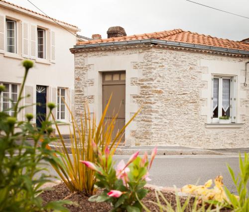 een stenen huis met een deur in een tuin bij Il Etait Une Fois Chez Moi La Chambre Augustin in Le Loroux-Bottereau