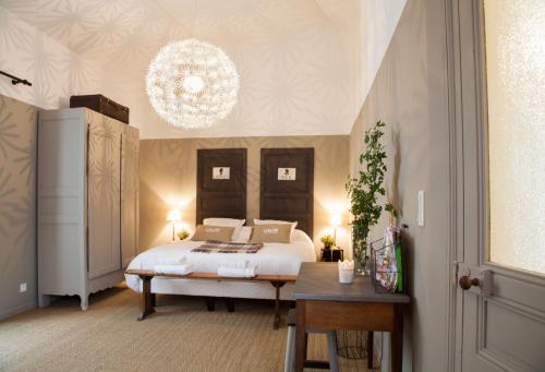 a bedroom with a bed and a chandelier at Il Etait Une Fois Chez Moi La Chambre Augustin in Le Loroux-Bottereau