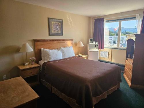una camera d'albergo con un grande letto e una finestra di Ocean Marina Hotel a Port Alberni