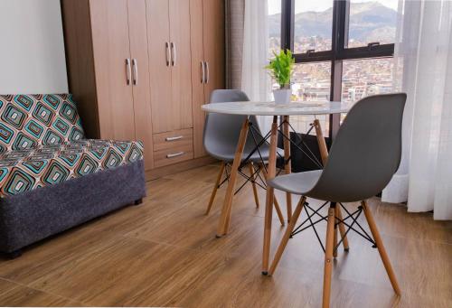 sala de estar con mesa, sillas y sofá en Samay Business Hotel and Departments en Cuzco