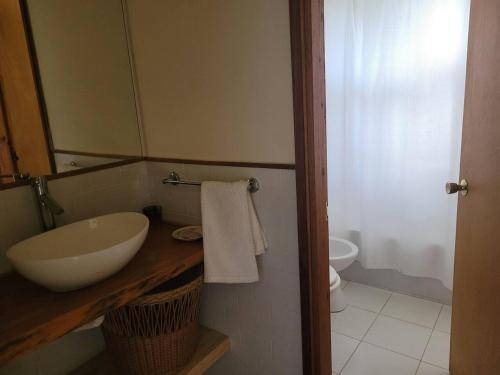 a bathroom with a sink and a mirror and a toilet at Casa en Las Perdices, Carmelo in Carmelo