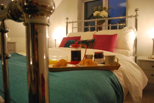a tray of food on top of a bed at Stylish-Stays Covert Cottage, Fleet Stylish Cottage, Parking, Patio, Dog Friendly, EV in Fleet