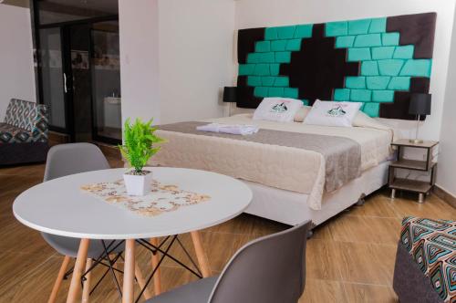 1 dormitorio con 1 cama, mesa y sillas en Samay Business Hotel and Departments en Cuzco