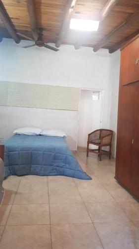 a bedroom with a blue bed and a chair at Monoambiente Blanca in Concordia