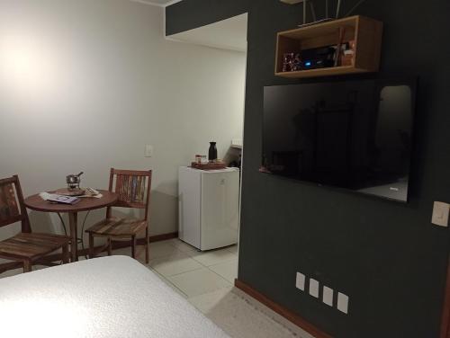 uma sala de estar com uma televisão e uma mesa de jantar em Casa da lu Itacoatiara -Suíte Andorinhas em Niterói