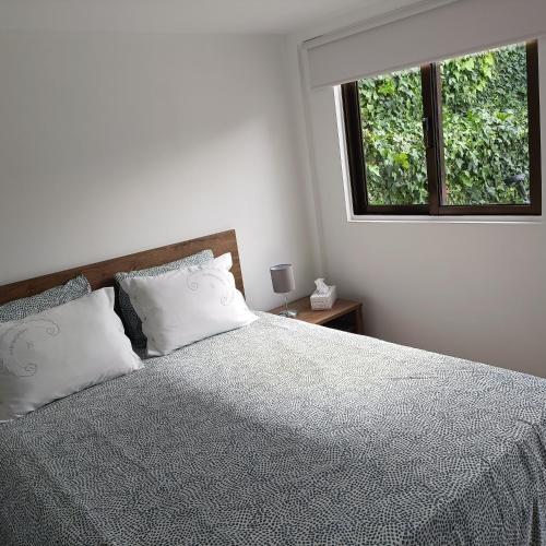 a bedroom with a bed with two pillows and a window at Guesthouse Monsanto in Porto