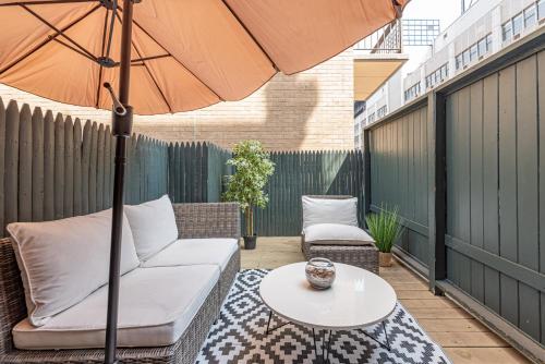 a patio with a couch and an umbrella and a table at 1BR in Midtown East! in New York