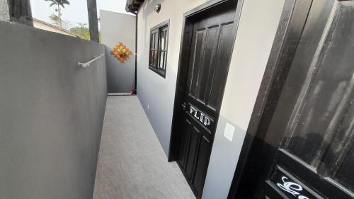 a hallway with a black door and a hallway with a floor at Flat In Paraty in Paraty