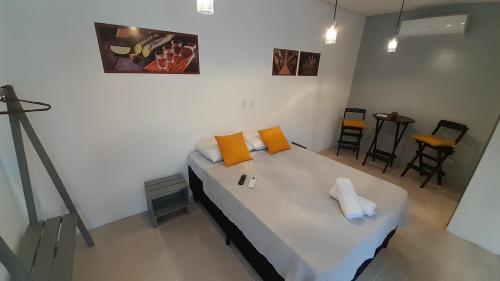 a bedroom with a bed with orange and white pillows at Flat In Paraty in Paraty
