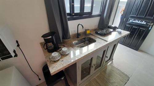 a kitchen with a sink and a coffee maker on a counter at Flat In Paraty in Paraty