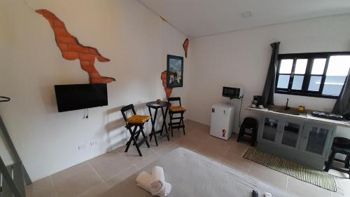 a living room with a tv and a table and chairs at Flat In Paraty in Paraty